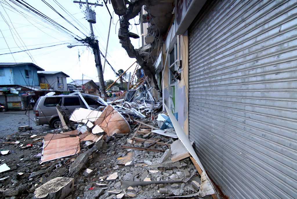 Un vehículo estacionado está atrapado bajo los escombros de un edificio escolar que fue dañada después de un terremoto de 6,5 grados de magnitud sacudió durante la noche en la ciudad de Surigao, en la isla meridional de Mindanao, el 11 de febrero de 2017. (Foto: ERWIN MASCARINAS / AFP / Getty Images)