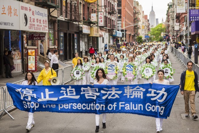 Los practicantes de Falun Dafa conmemoran a los compañeros practicantes que perdieron sus vidas debido a la persecución en China, como parte de un gran desfile de Falun Dafa en Chinatown de Manhattan, un 18 de mayo. (Edward Dai/La Gran Época)