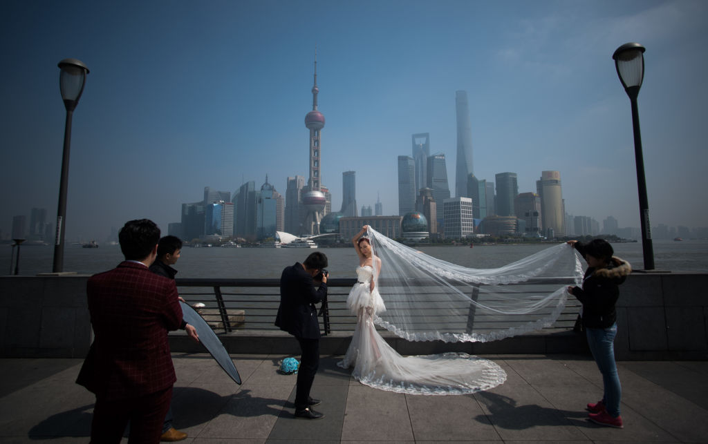 Una mujer posa para una foto de una boda en frente del distrito financiero de Pudong en Shanghai el 19 de marzo de 2015. (JOHANNES EISELE / AFP /Getty Images)